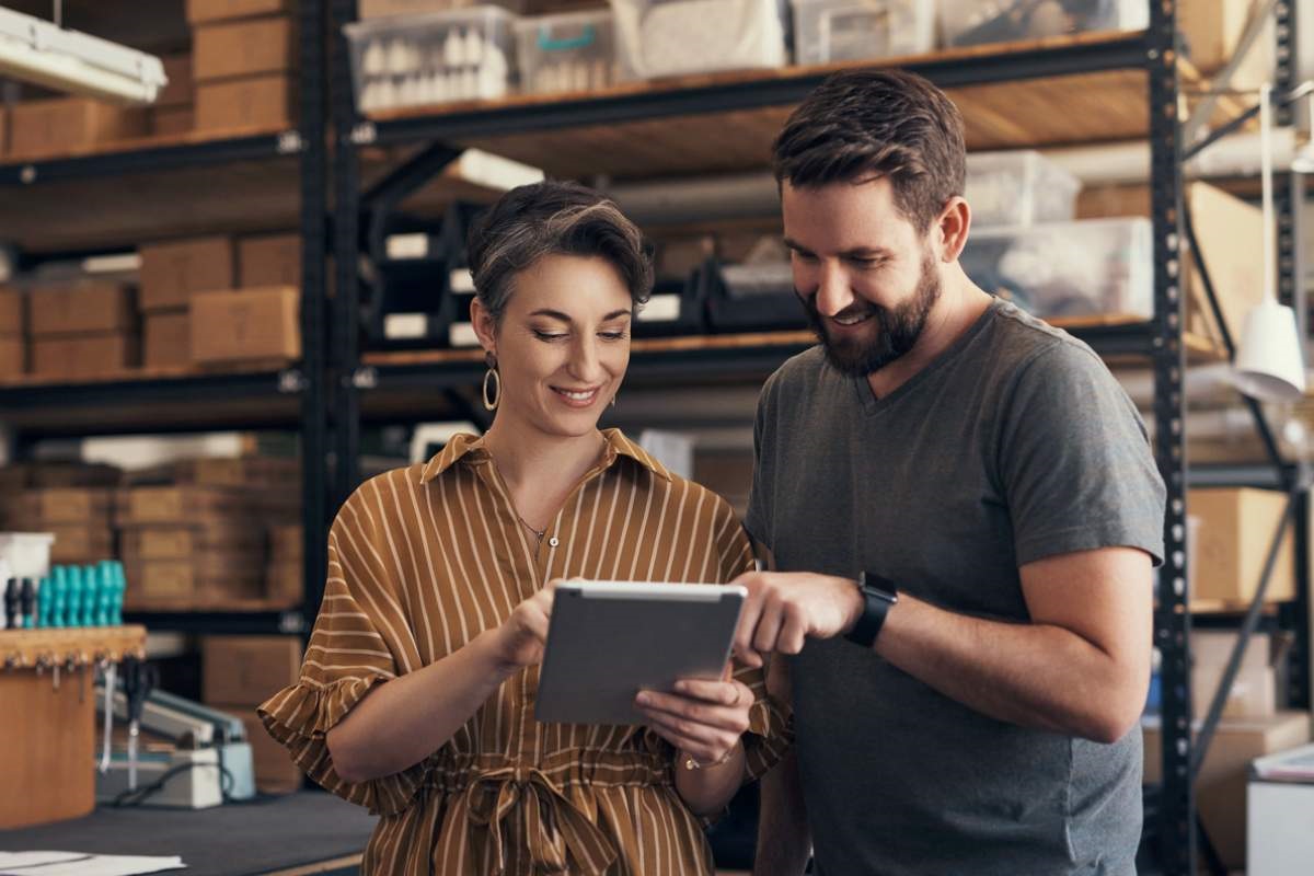 Business owners doing inventory forecasting in warehouse