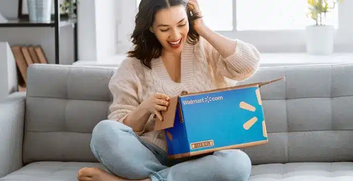 A woman sitting on couch with a Walmart box.