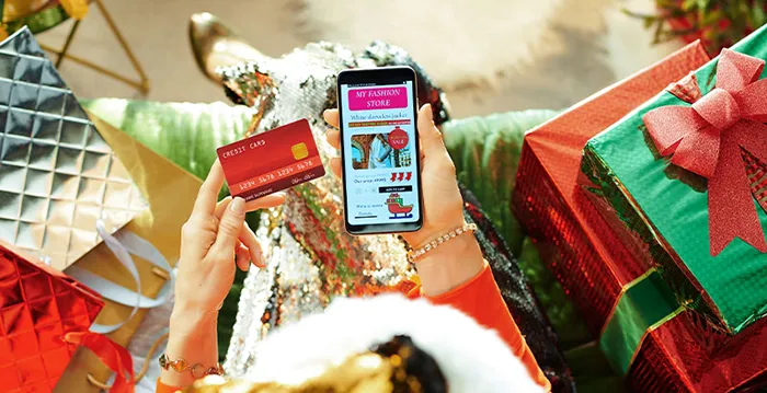 A person holding a phone and a credit card.