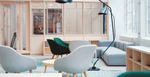 A room with a couch and chairs.