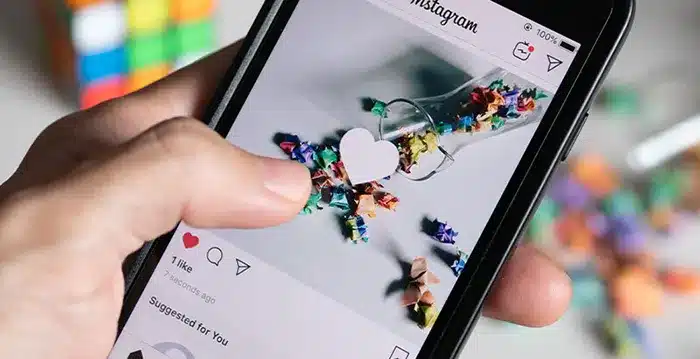 A hand holding a mobile phone with Instagram.