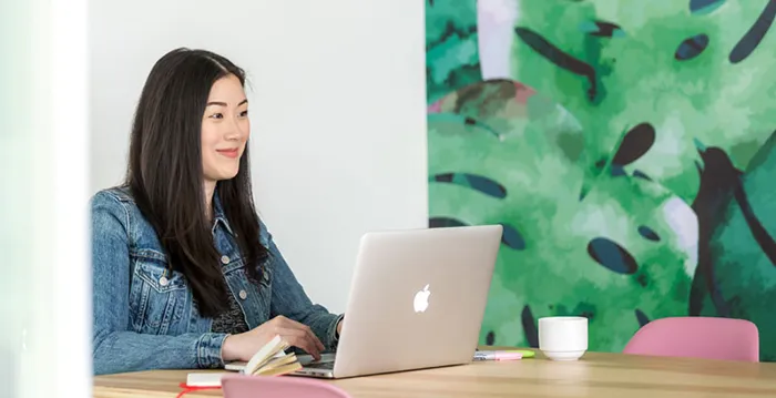 A woman sitting at a table with a laptop.