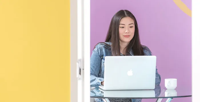 A woman sitting at a desk with a laptop.