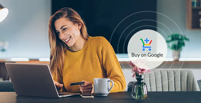A woman sitting at a table with a laptop and a cup of coffee.