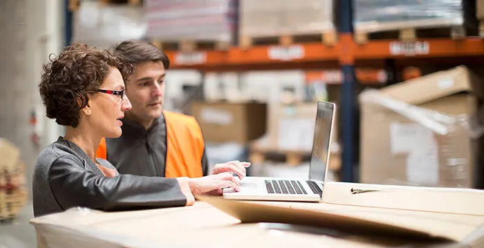 A man and a woman looking at a laptop.
