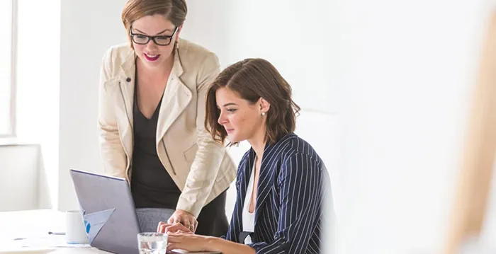 A woman and a man looking at a laptop.