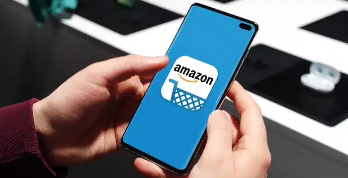 Person holding phone with Amazon on screen.