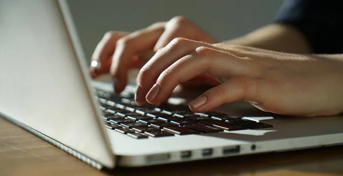 A person typing on a laptop.