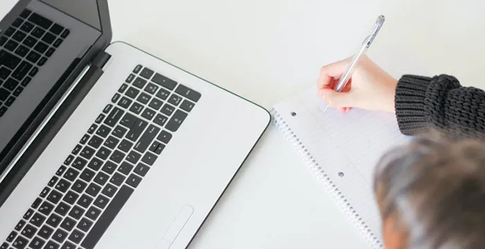A person writing on a piece of paper.