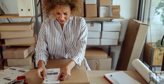 A small business owner uses an order management system to package products.