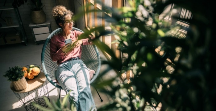 A women sitting in a chair in a garden.