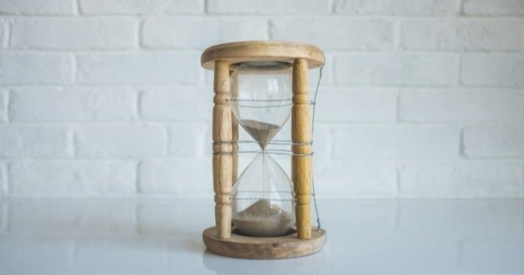 A wooden hourglass in a white room
