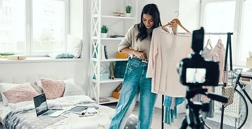 A woman in a bedroom choosing clothes.