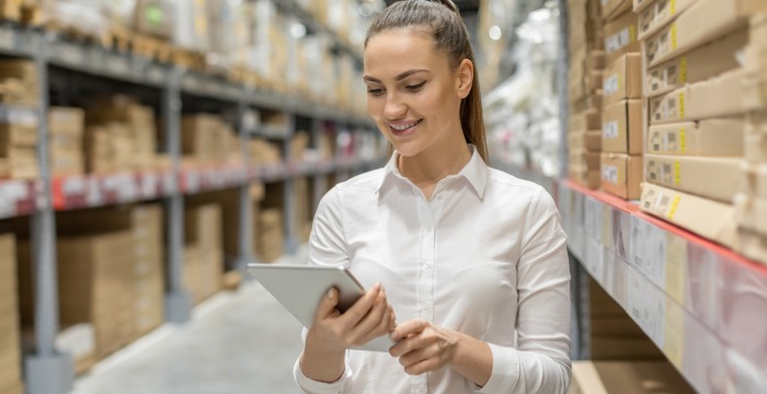 Young woman auditing inventory in warehouse