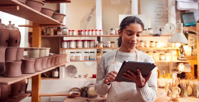 Woman in pottery store using retail inventory mangement software