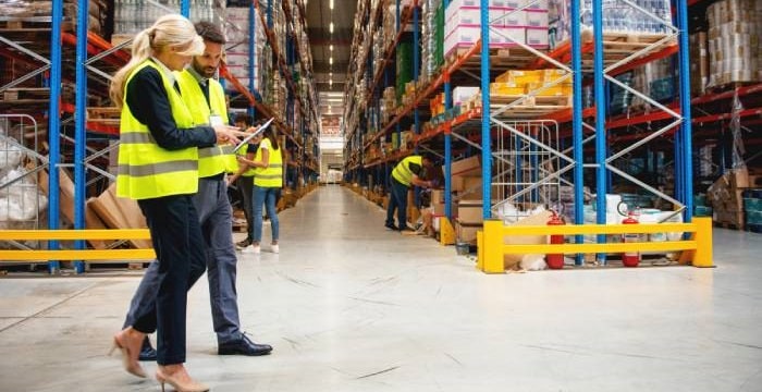 Warehouse workers assessing inventory control measures