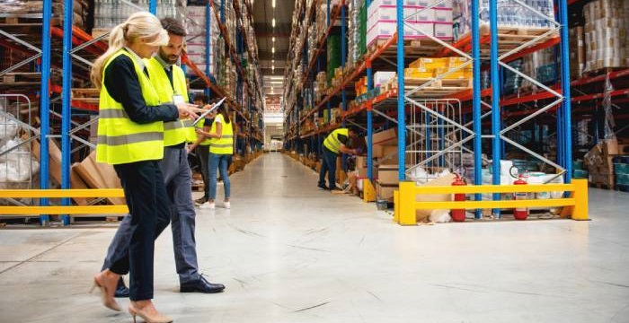 Warehouse workers assessing inventory control measures