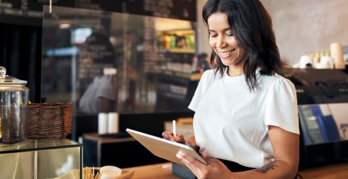 Barista checking inventory on tablet