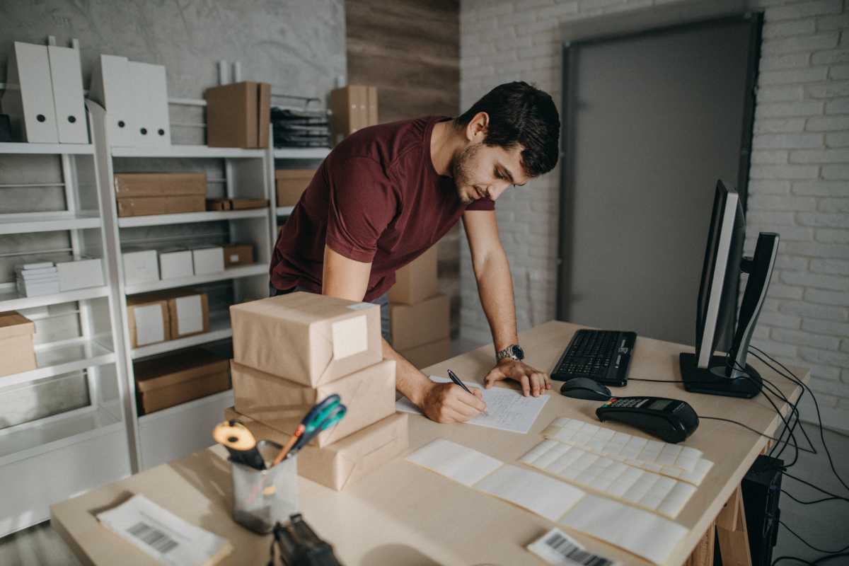 Man packing orders and calculating the best shipping rates