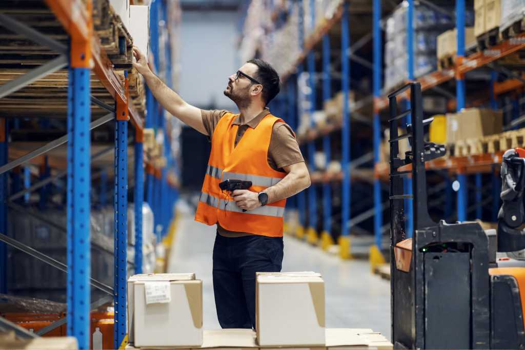 Warehouse worker checking minimum stock levels with scanner