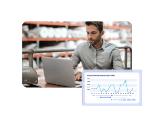 Warehouse manager analyzing sales performance data by SKU on a laptop, reviewing charts for insight reporting.
